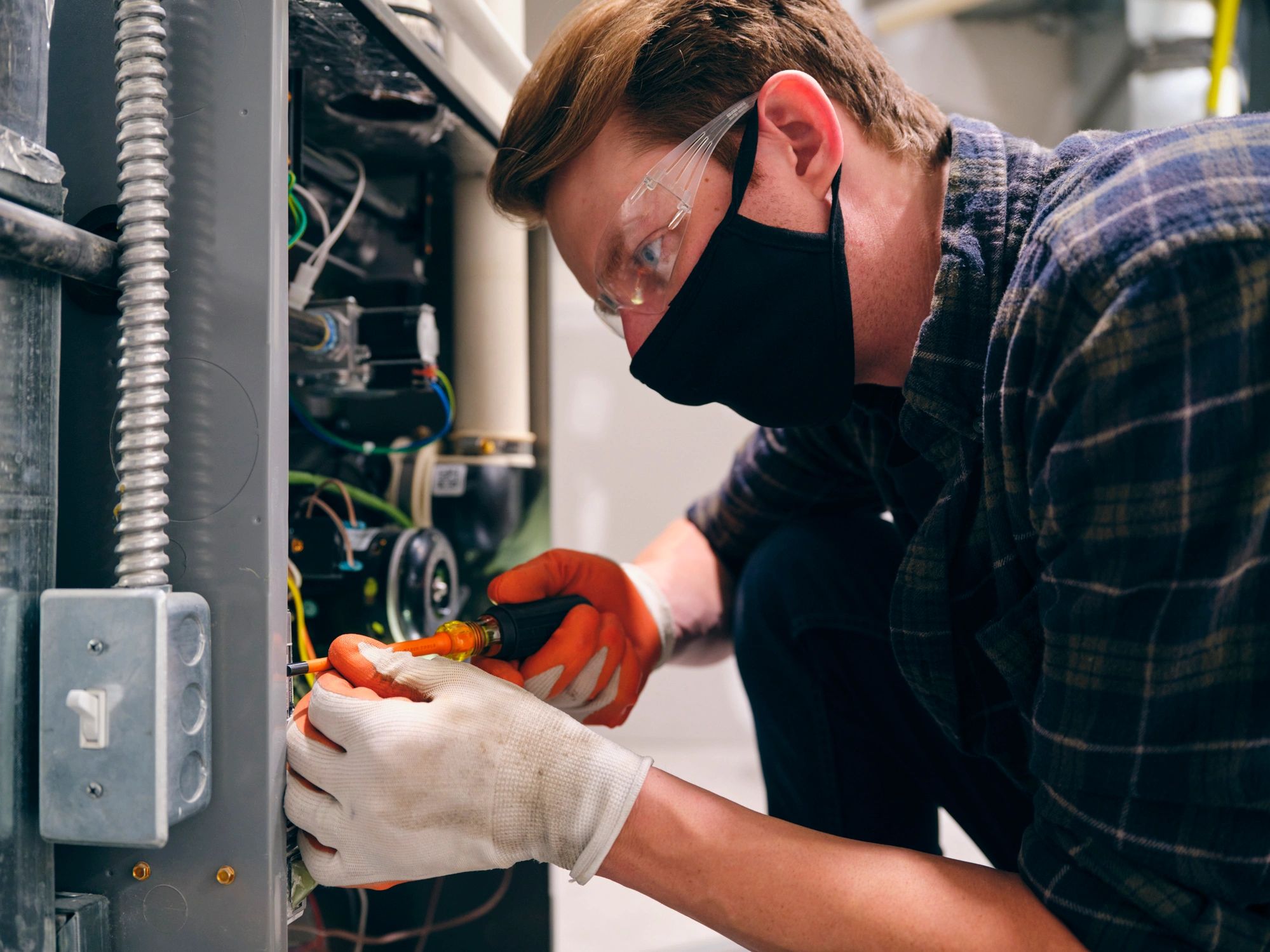 Technician performing an HVAC repair inside a home