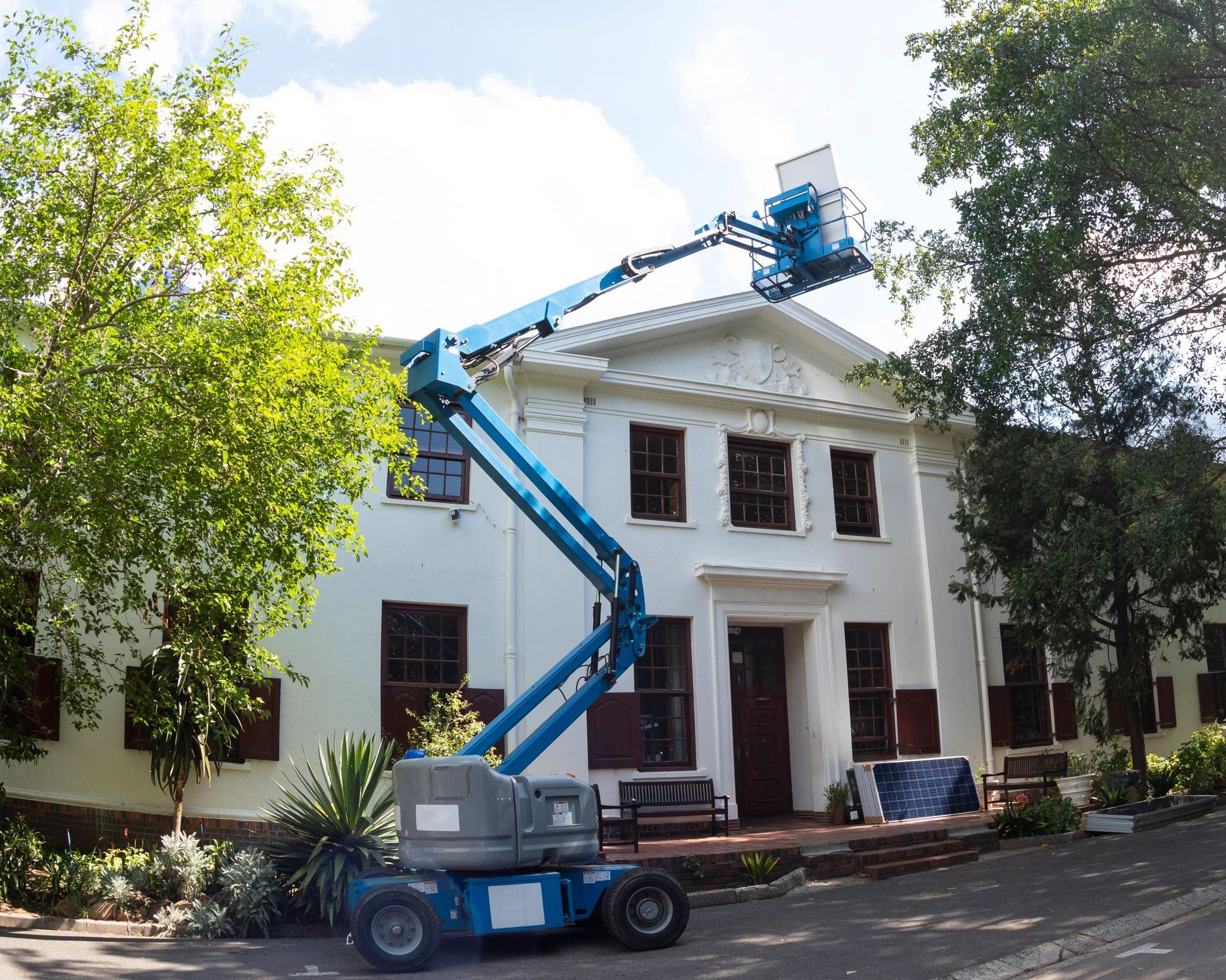 Technicians working on rooftop equipment using a lift